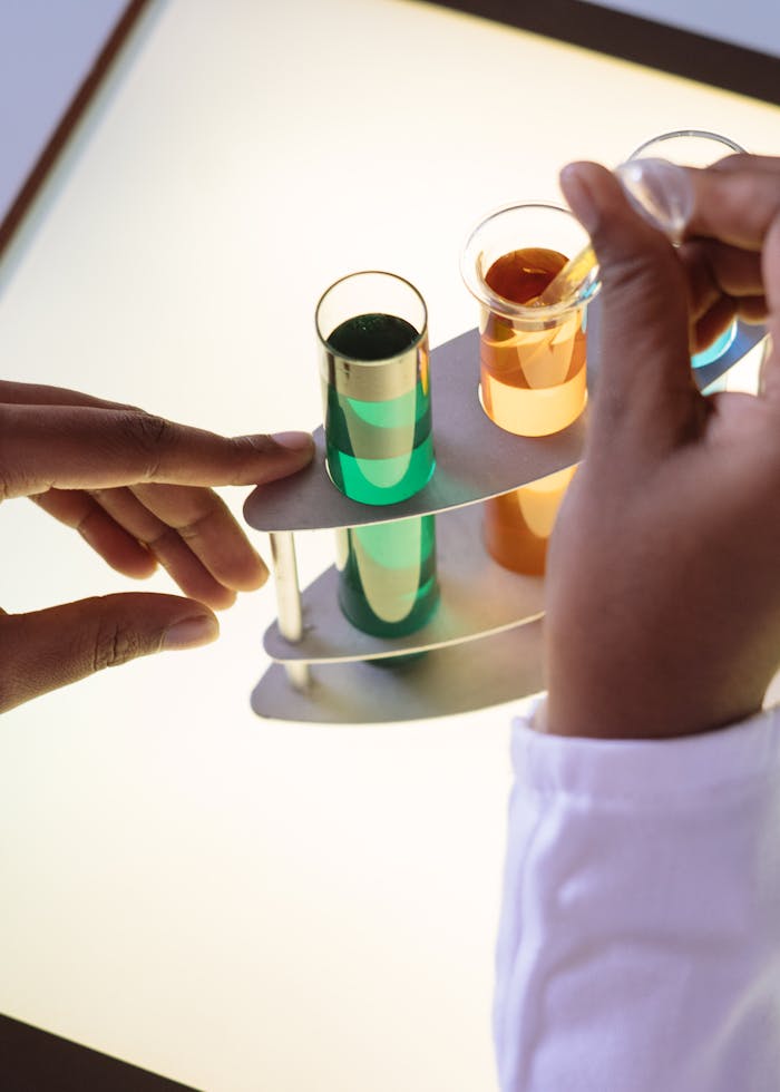 services-04 Crop laboratory technician in white uniform using pipette for taking sample from test tube during biochemical experiment in researching center